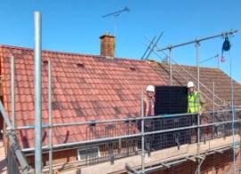 Image shows solar panel on a roof in Ipswich ready for install with Cllr Ross and Project Officer.