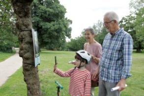 Image shows a family enjoying a temporary AR trail in Christchurch Park