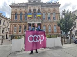 Councillor John Cook with the International Co-operatives Alliance flag 