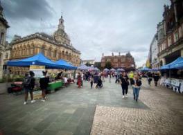 Image shows Ipswich Cornhill with lots of blue gazebos and people at an event in early August 2023
