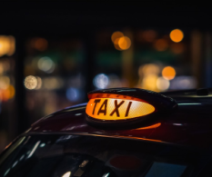 Image shows a London taxi sign at night