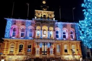 Image shows Ipswich Town Hall lit up with Christmas Lights with Christmas tree alongside