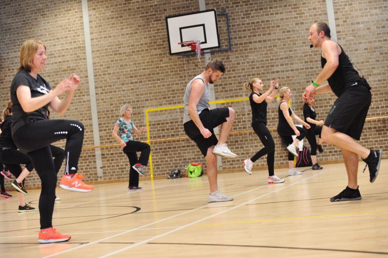 People enjoying exercise in a sports hall