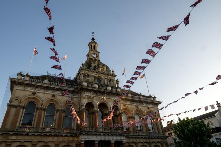 Exterior with Union Jack flags and bunting flying from Ipswich Town Hall