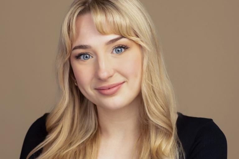 Woman with long blond hair wearing a black dress