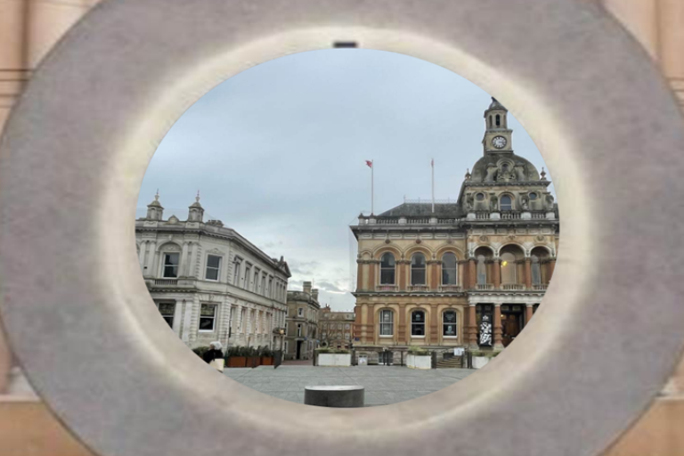 A circular stone sculpture showing a view of a town square