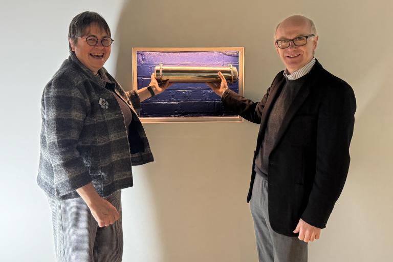 Two people hold a time capsule placed at Ipswich Regent Theatre