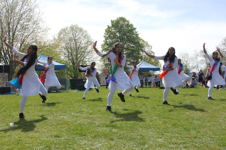 A group of people performing traditional Indian dance in a park