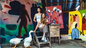 Two women artists pictured with their paintings