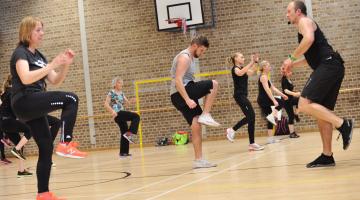 People enjoying exercise in a sports hall