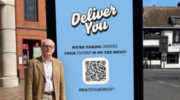 Councillor Neil MacDonald standing next to one of the digital screens in Ipswich town centre.