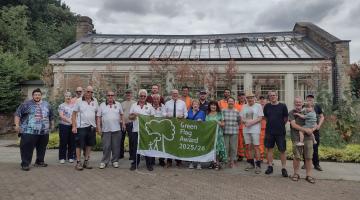 Group of people display Green Flag awarded to Holywells Park in Ipswich