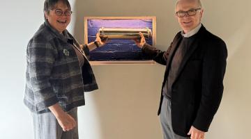 Two people hold a time capsule placed at Ipswich Regent Theatre