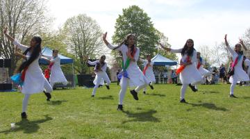 A group of people performing traditional Indian dance in a park