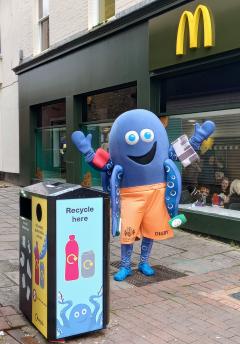 DiGBY with a plastic bottle and can recycling bin in Ipswich town centre